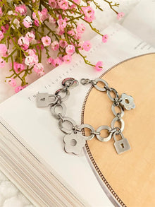 Pulsera de acero plateado gruesa de mujer con dijes